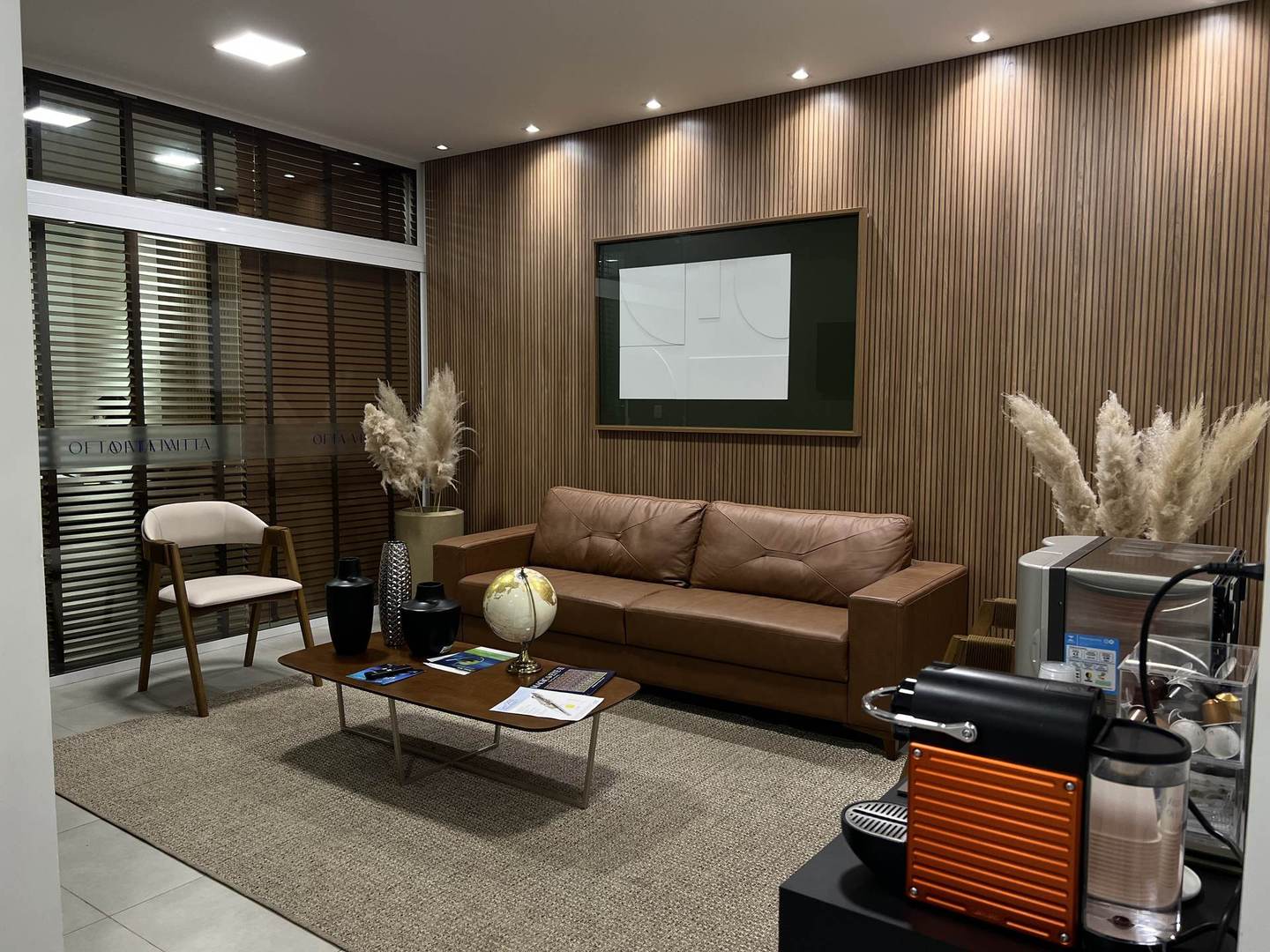 Sala de espera do OFTA VITTA com sofá e painel de madeira