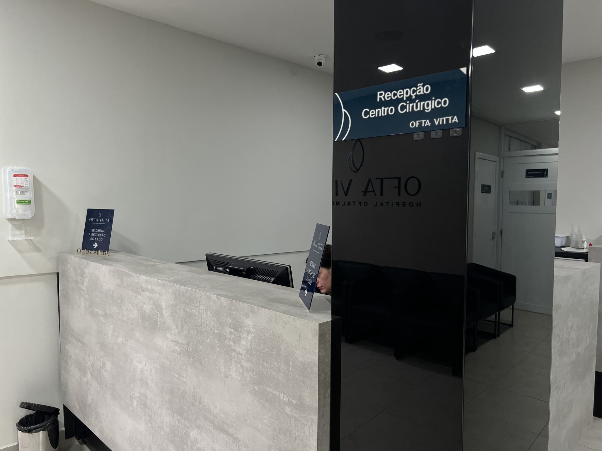 Recepção do Centro Cirúrgico OFTA VITTA, balcão em cimento queimado e placa de sinalização